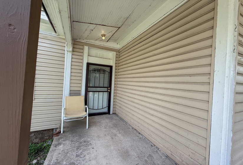 Front entry featuring a security screen door and light-colored siding