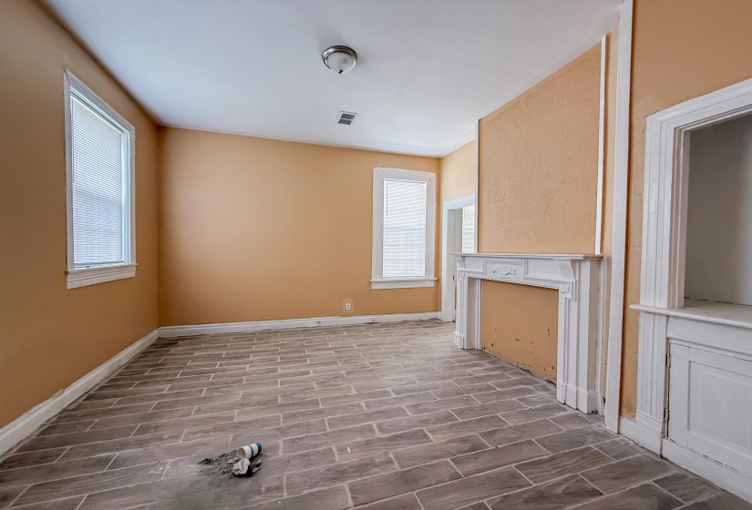 Room featuring wood-look tile flooring and a decorative fireplace with a substantial mantelpiece