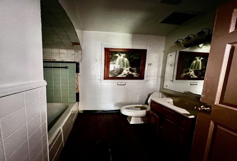 Full bathroom with vanity, tile walls, and dark wood-style flooring