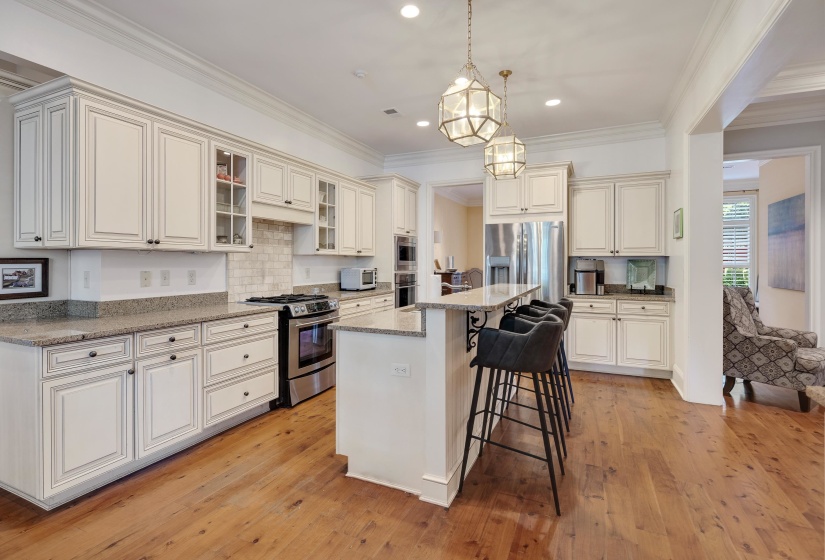Spacious kitchen featuring extensive cabinetry, stone countertops, and wood-finish flooring