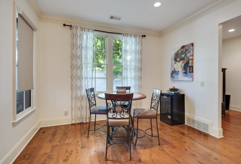Hardwood flooring extends throughout this room, featuring tall baseboards and crown molding