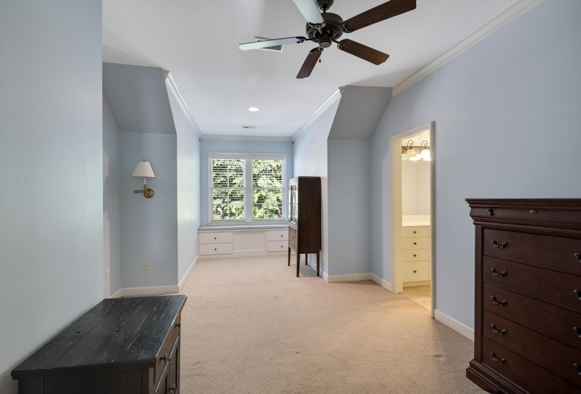 Carpeted bedroom featuring a ceiling fan, recessed lighting, and a window seat with built-in cabinetry