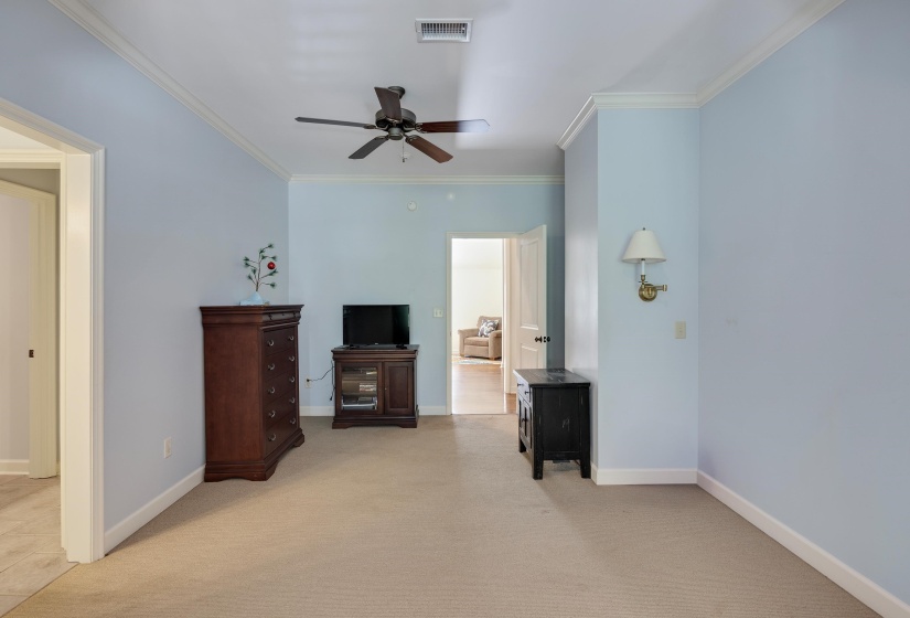Carpeted room with light blue walls and white crown molding