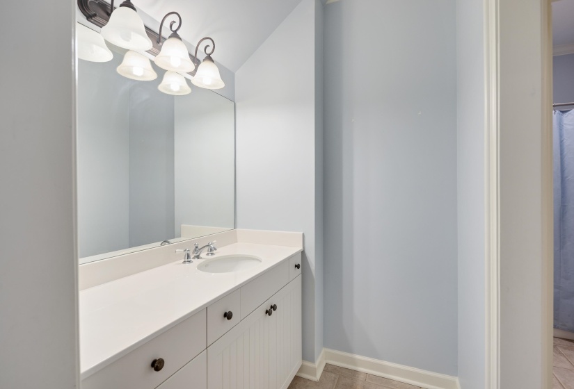 Bathroom vanity featuring a single integrated sink, chrome faucet, and expansive countertop
