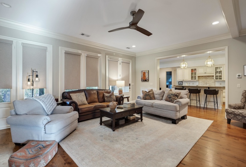 Spacious living area featuring wood-finish flooring, crown molding, and recessed lighting