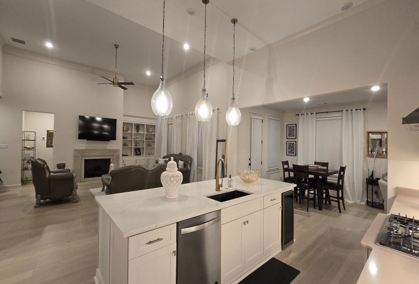 Spacious kitchen island with a built-in sink, stainless steel dishwasher, and under-counter beverage cooler