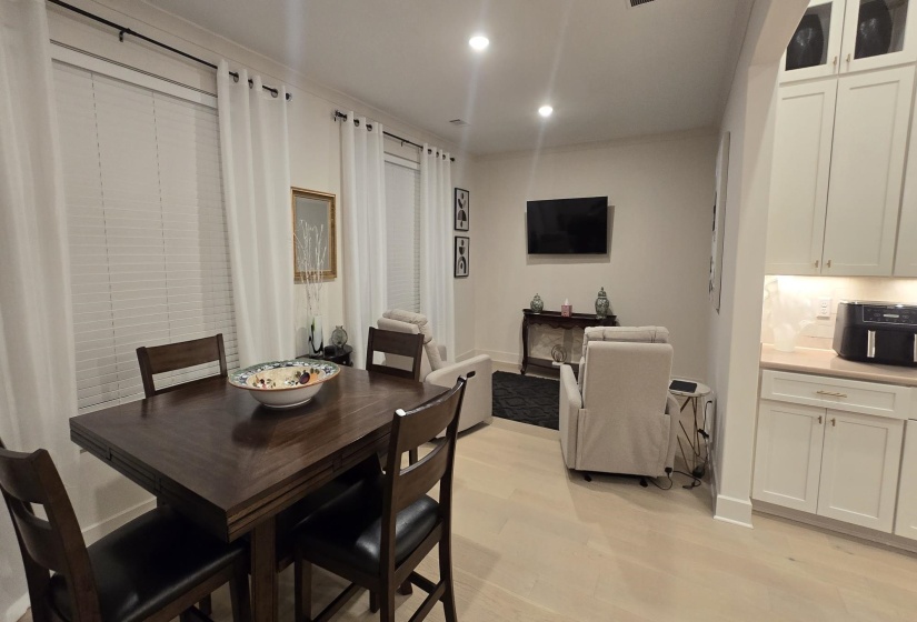 Open-concept living space featuring wood-finish flooring, recessed lighting, and crisp white walls
