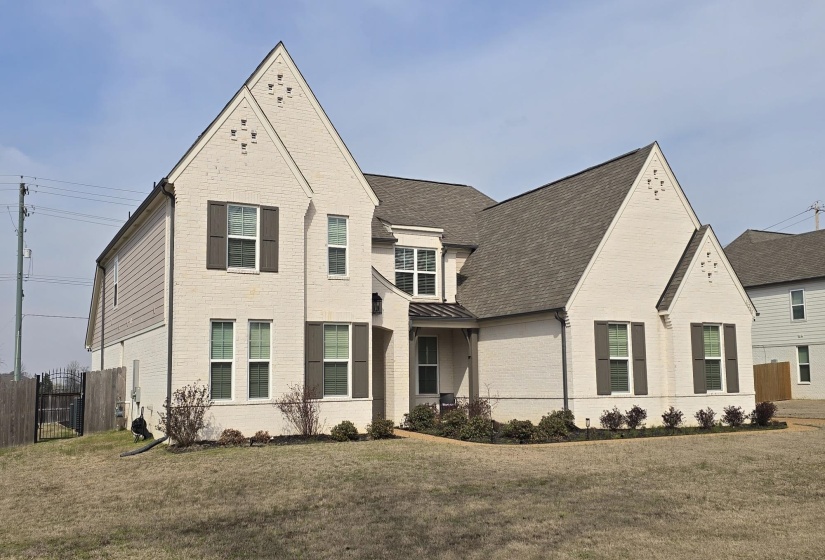 Two-story residence featuring light-colored brick and horizontal siding accents