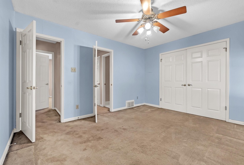 Room featuring light blue walls, a textured ceiling, and neutral-toned carpeting