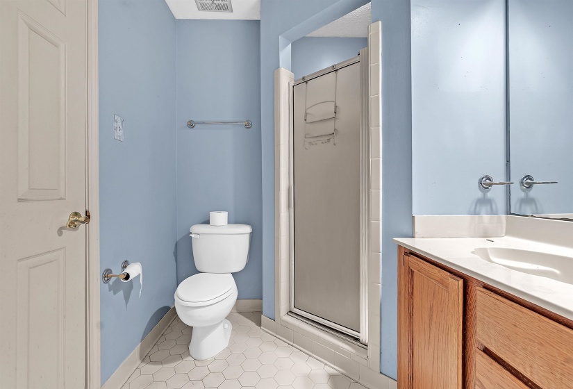 Bathroom featuring a built-in vanity with wood-finish cabinetry and an integrated sink