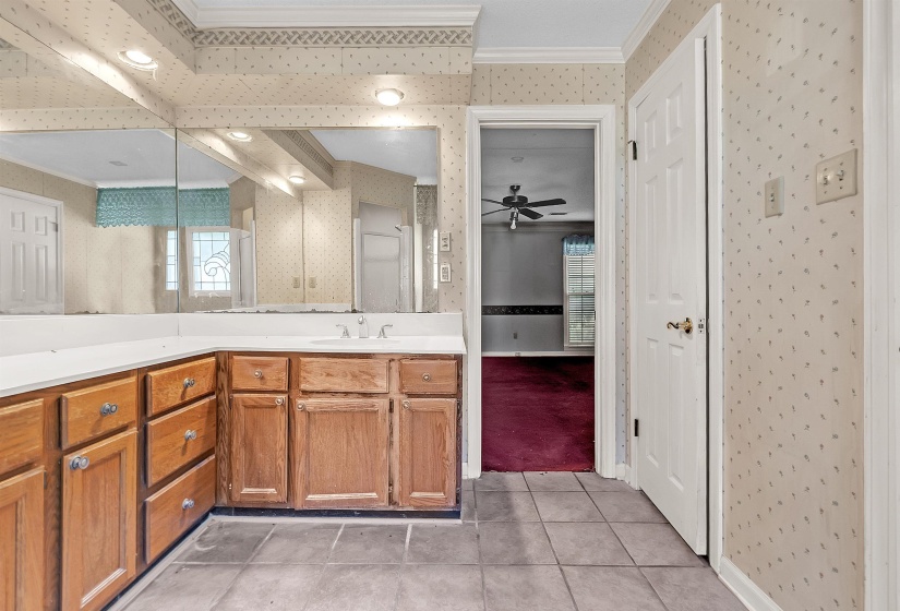 Bathroom vanity featuring a light-toned countertop with a single sink