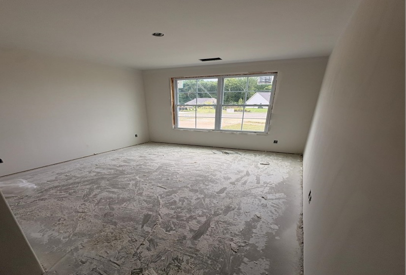 Room featuring a large multi-pane window, white painted walls, and a ceiling-mounted light fixture