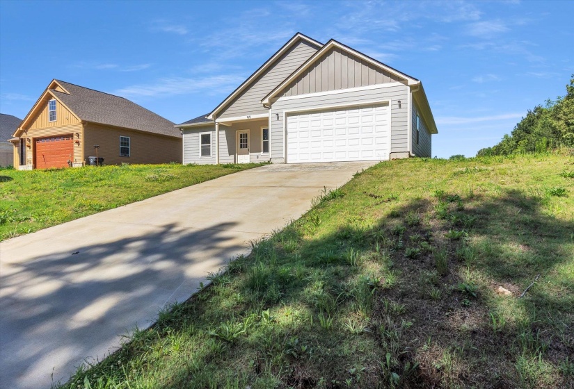 Contemporary ranch-style home featuring light gray siding and a white garage door