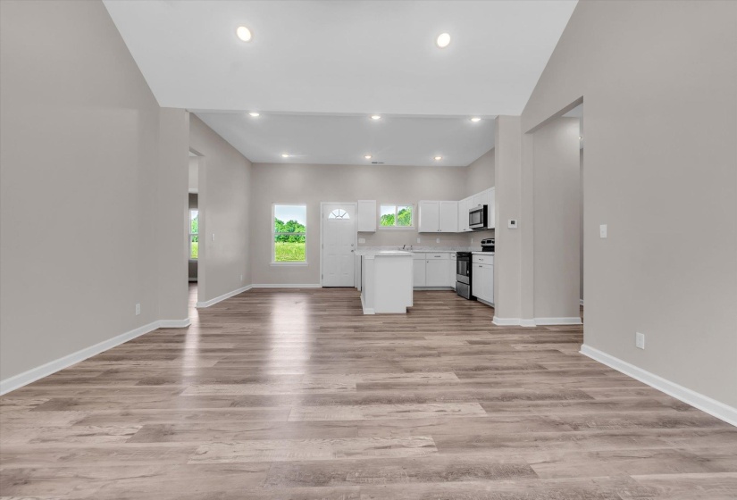 Open concept living area featuring wood-finish flooring and recessed lighting