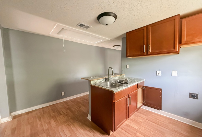 Utility area featuring wood-finish flooring and light gray walls