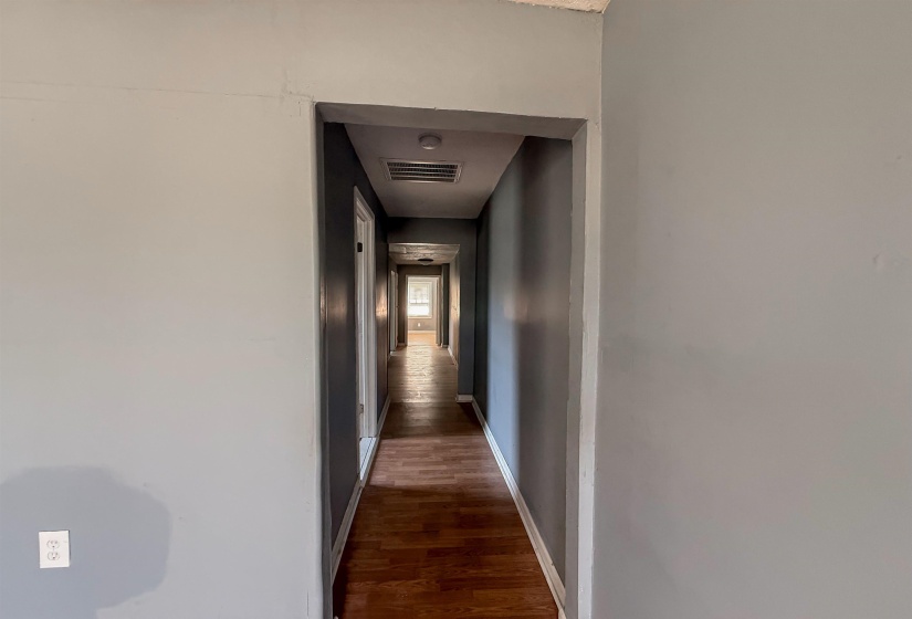 Hallway featuring wood-finish flooring, light gray walls, and recessed lighting