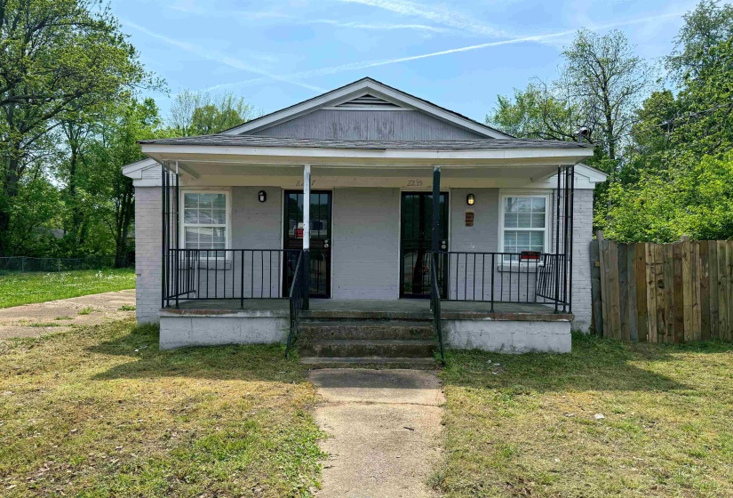 Duplex property featuring a covered front porch with black railings, a light gray exterior, and multiple windows