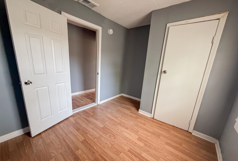 Room featuring wood-finish flooring, light gray walls, and white trim