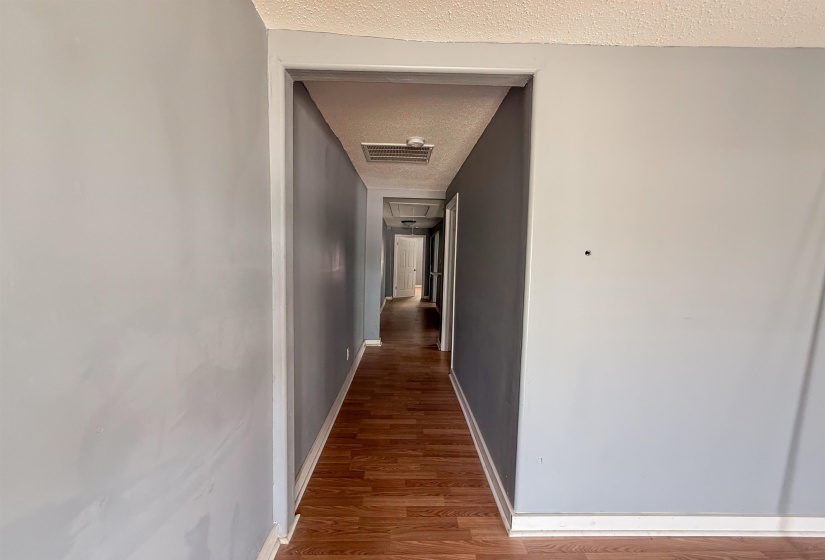 Hallway featuring wood-finish flooring and light gray painted walls
