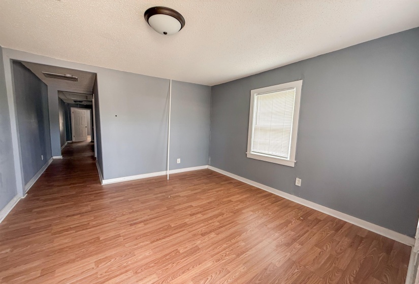 Room featuring wood-finish flooring, light gray wall color, and white baseboards