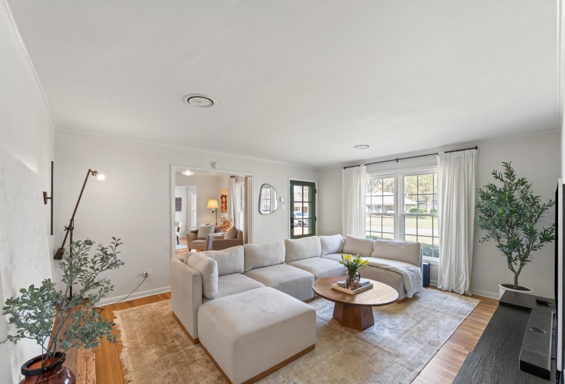Living room with ornamental molding and light wood finished floors