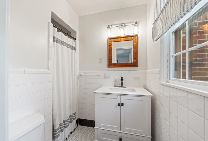 Bathroom with vanity, a shower with curtain.
