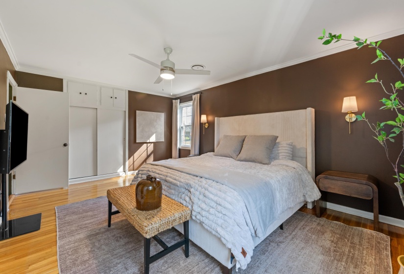 Bedroom featuring ornamental molding, a closet, light wood-style floors, and ceiling fan