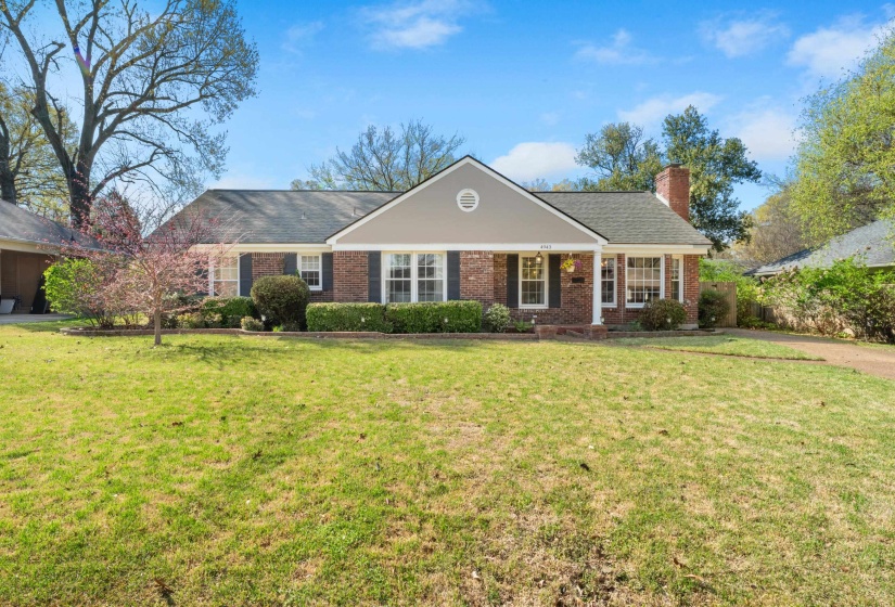 Ranch-style home with a front lawn, brick siding, and a chimney