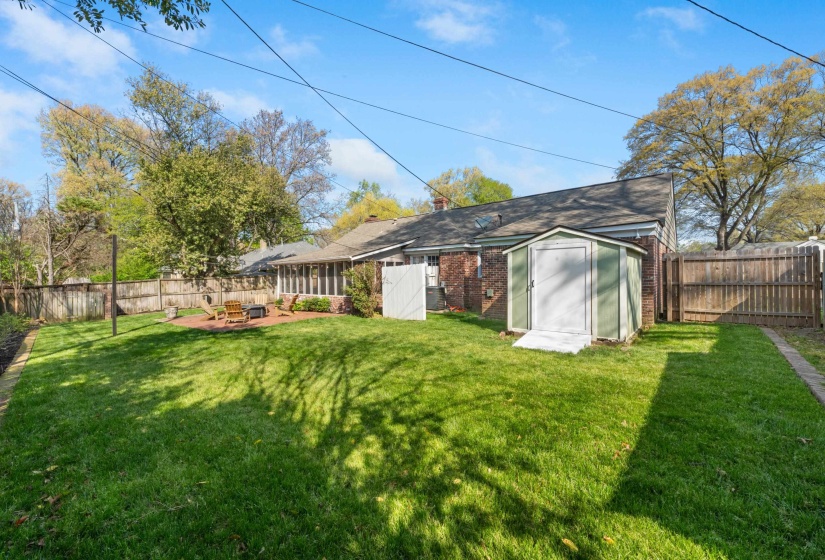 Fenced backyard featuring a storage shed and a patio