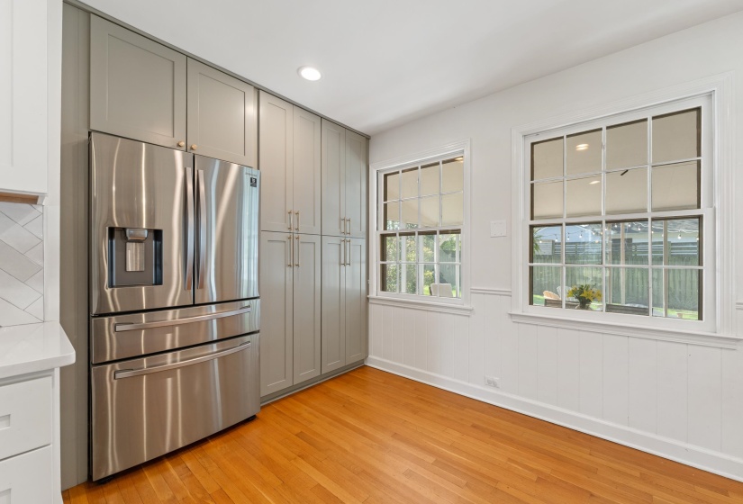 Kitchen featuring stainless steel fridge, gray cabinets, light wood-type flooring, recessed lighting, and wainscoting