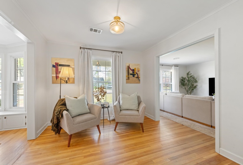 Sitting room with light wood-style floors and ornamental molding