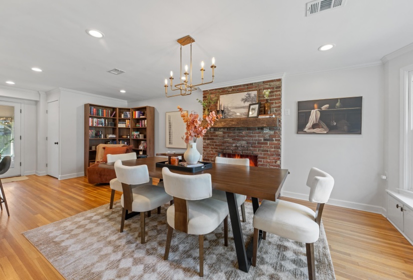 Dining space featuring light wood-style floors, ornamental molding, and suspended lighting