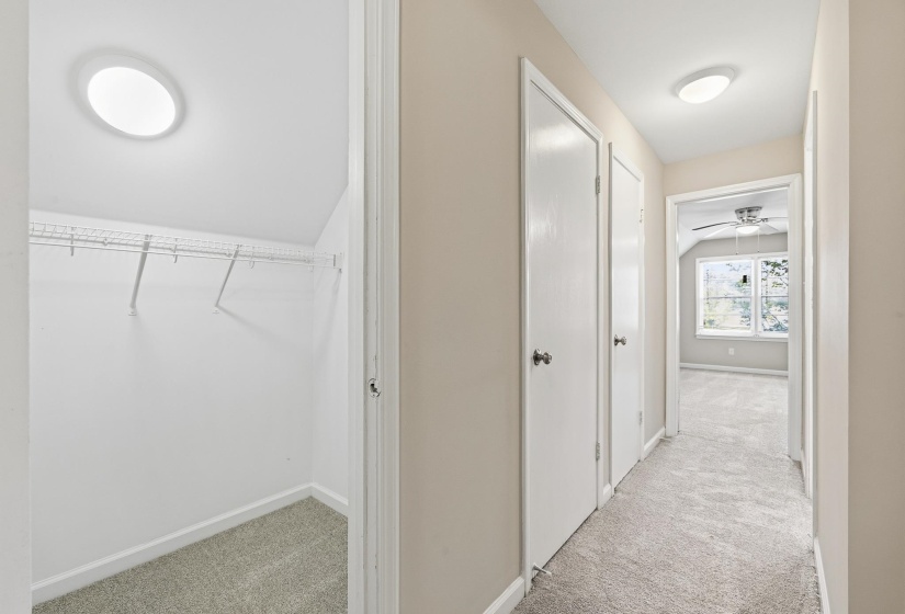 Hallway featuring light beige walls and grey carpet flooring