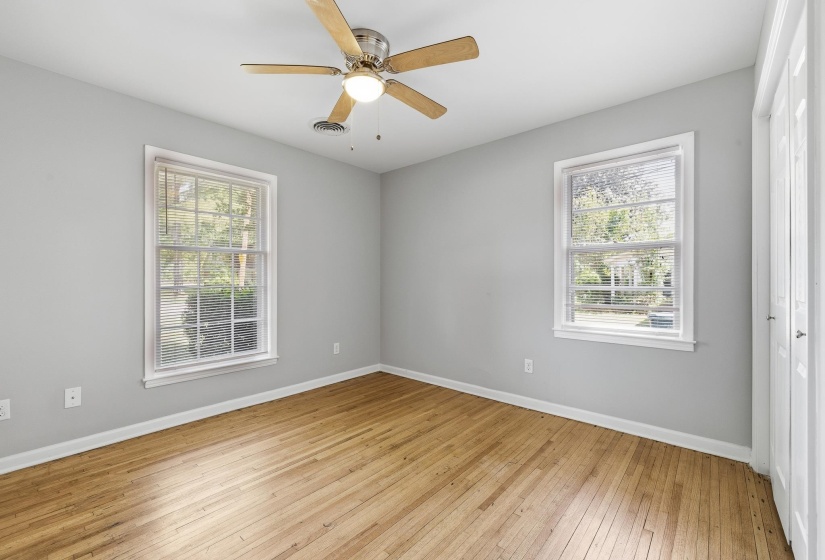 Bright room featuring wood-finish flooring, light grey walls, and white trim