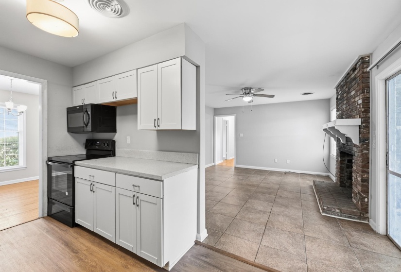 Kitchen featuring white cabinetry, light-colored countertops, and black appliances