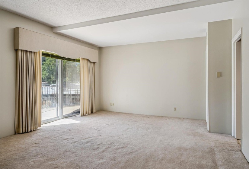 Spacious interior room featuring light-colored wall-to-wall carpeting and neutral painted walls