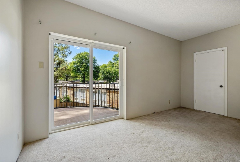 Room featuring light-toned carpeting and a vaulted ceiling