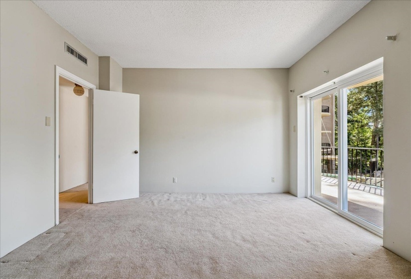 Carpeted room with neutral wall paint and a textured ceiling