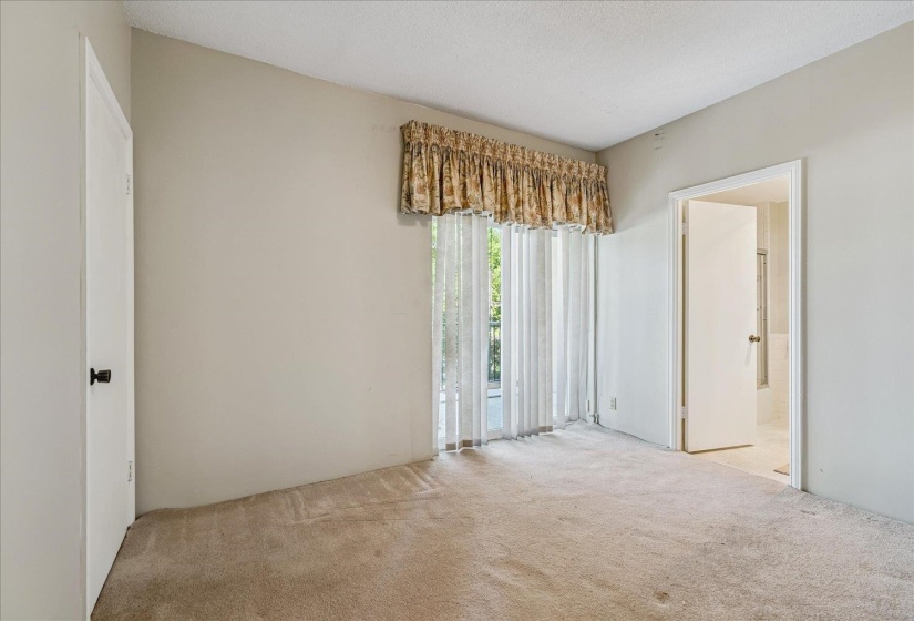 Spacious room featuring neutral carpeting, light-toned walls, and a vaulted ceiling