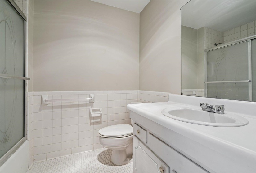 Bathroom featuring a single vanity with an integrated sink, polished chrome faucet, and a large wall-mounted mirror