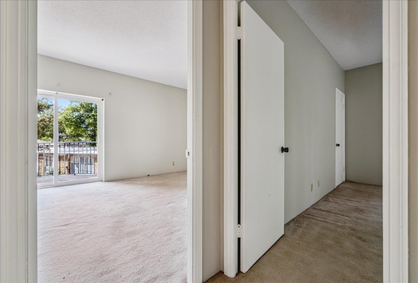Room featuring neutral carpeting, a sliding glass door, and a private balcony with metal railings