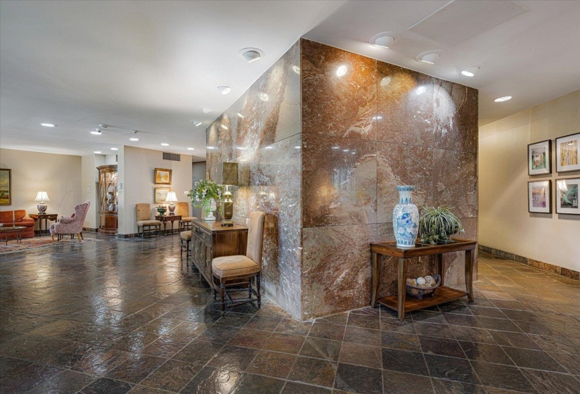 Expansive foyer featuring stone tile flooring, a large stone accent wall with integrated lighting, and recessed ceiling lighting