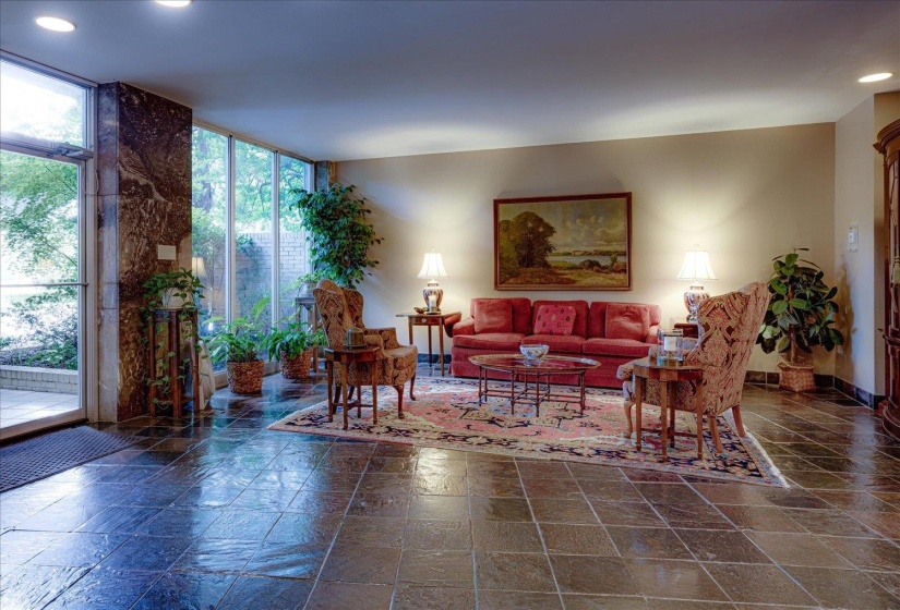 Spacious living area featuring large-format slate tile flooring and a wall of floor-to-ceiling windows