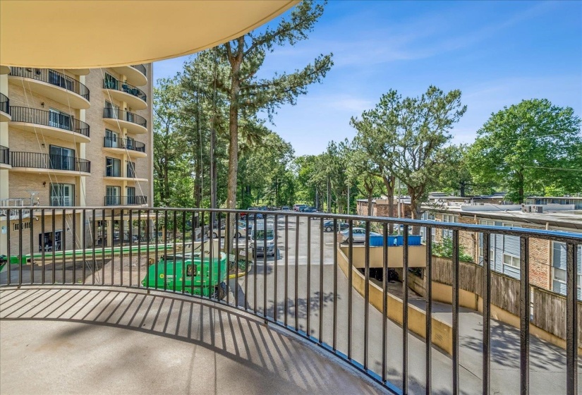 Curved concrete balcony featuring black iron railings