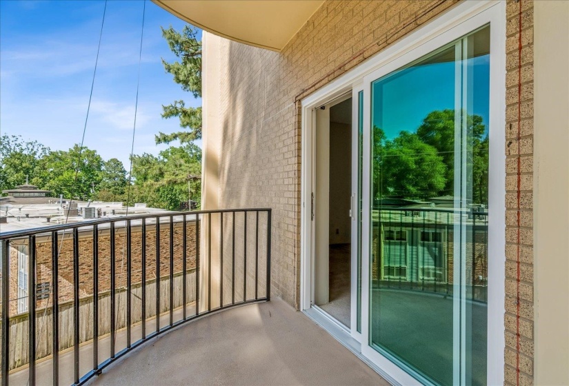 Curved balcony featuring a black metal railing and concrete flooring