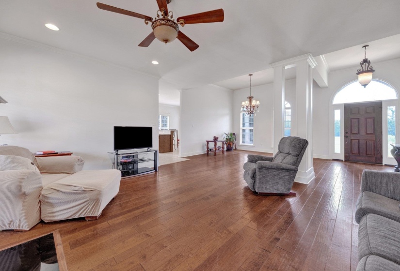 Spacious living area featuring wood-finish flooring, recessed lighting, and a decorative ceiling fan
