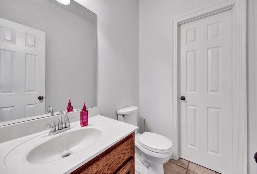 Bathroom featuring a wood-finish vanity with an integrated sink and chrome faucet