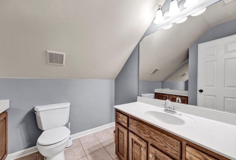 Bathroom featuring a vanity with wood-finish cabinetry, a white countertop, and an undermount sink