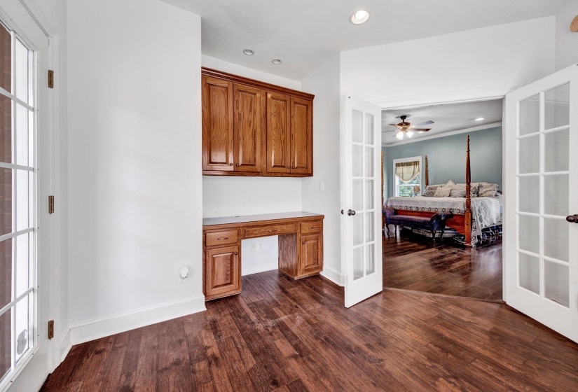 Built-in wood-finish cabinetry and desk area with recessed lighting, complemented by wood-finish flooring