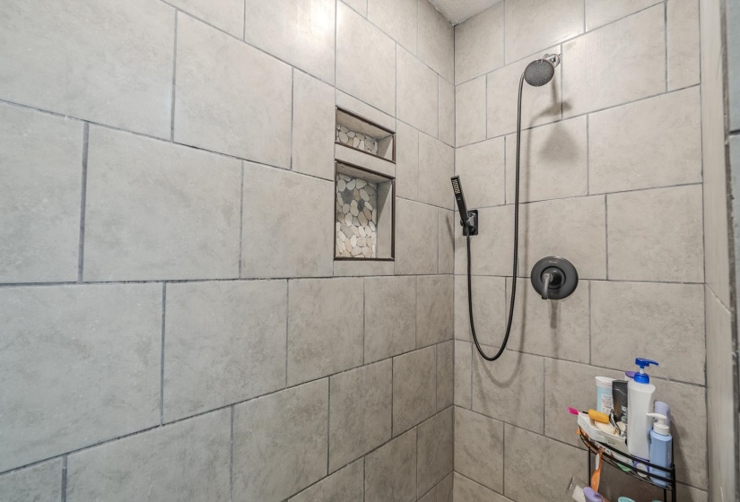 Tiled shower enclosure featuring a dual shower head system with matte black fixtures